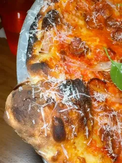 Customers enjoying NY-style pepperoni pizza at Bad Boys in Bethnal Green, London, highlighting the vibrant food scene.