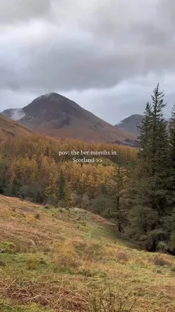 Excited adventurer enjoying a drive in the Scottish Highlands during autumn, embracing nature and winter activities.