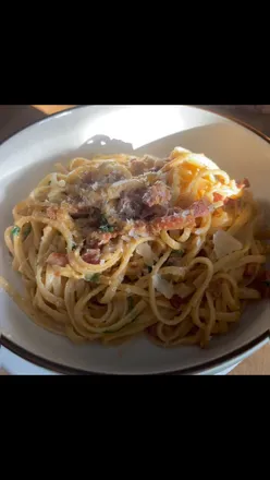 Homemade carbonara pasta featuring pancetta and cheese, perfect for a comforting supper at home.
