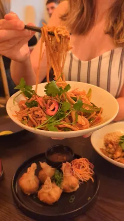 Guests enjoying delicious Thai tapas at Mangosteen Bristol's opening on Gloucester Road, featuring Mie Goreng and Pad Thai.