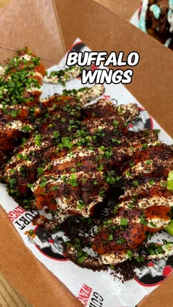 Attendees enjoying a variety of chicken wings at Wing Fest Bristol, featuring massive Korean BBQ wings from Bad Boy Wings.