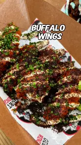 Attendees enjoying a variety of chicken wings at Wing Fest Bristol, featuring massive Korean BBQ wings from Bad Boy Wings.
