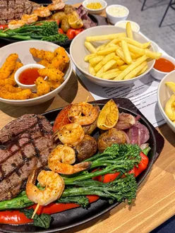 Surf and Turf Royale at Beija Flor in Dinas Powys, featuring perfectly cooked meat and prawns with delicious sides.