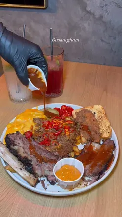 Brisket platter and loaded fries at Holy Smokes BBQ in Birmingham, showcasing tender smoked meat and delicious sides.