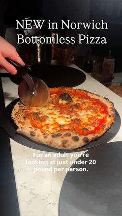 Group enjoying bottomless pizza with an array of toppings at Moto Pizza in Norwich, perfect for large gatherings and dietary needs.