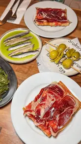 Couples enjoying a tapas date night at Broken Eggs, featuring sangria and signature dishes, while earning OpenTable rewards.