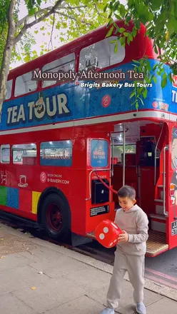 Family enjoying Monopoly-themed afternoon tea on a double-decker bus in London, featuring treats from Brigit's Bakery.
