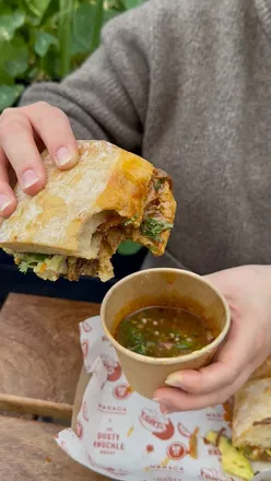 Delicious Birria Torta sandwich with beef, grilled cheese, and avocado from Wahaca and Dusty Knuckle in London.