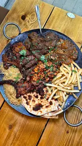 Delicious sharing platter with chicken tikka, lamb chops, and naan at a vibrant restaurant in Hertfordshire.