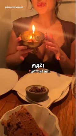 Customers enjoying a cozy Greek meal at Mazi, Notting Hill, surrounded by warm ambiance and sharing plates.