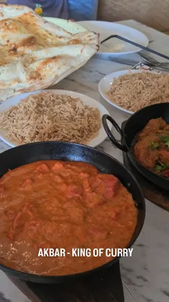 Delicious Indian meal at Akbar’s in Bradford featuring tikka, rogan josh, korma, garlic naan, and pilau rice.