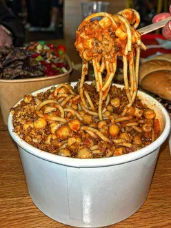 Delicious Koshary served with macaroni, rice, and chickpeas at Masri Egyptian Street Food, featuring vegan options.