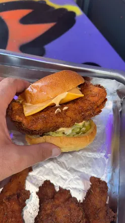 Fried chicken feast at The Nashville Cluck in Liverpool, showcasing crispy chicken and bold sauces.
