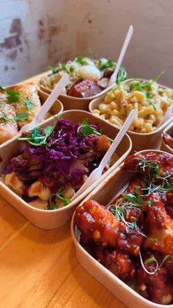 Delicious food spread at Street Food Atelier in Belfast, featuring mac & cheese, duck waffles, and sweet potato fries.