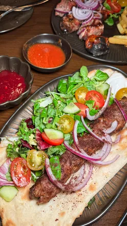 Delicious Georgian starter selection at Genatsvale, Cardiff, featuring pkhali, blinis, and pan-fried aubergine rolls.