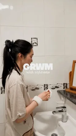 Person showcasing new skincare products from STYLEVANA for autumn transition, with K-Beauty items arranged aesthetically.