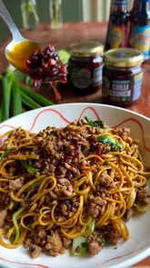 Delicious Crispy Pork Dan Dan-Style Noodles topped with Blue Dragon Chilli Crunch, available at Dunnes and Tesco.
