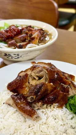 Alt text: "Dishes of duck with rice, char siu noodles, and salt & chilli chips at Yong Sheng cafe in Newcastle supermarket.