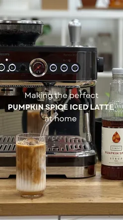 Iced pumpkin spice drink made with Philips Barista Brew, featuring espresso, milk, and autumn decor.