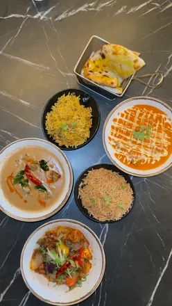 Delicious Indian dishes at Delhi House, featuring Tandoori Butter Chicken Wings, Fish Tikka, and Kerala Lamb Stew.