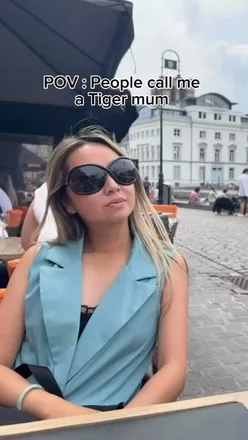 Girl playfully posing as her mother's assistant, embodying 'mini me' energy with humor and style.