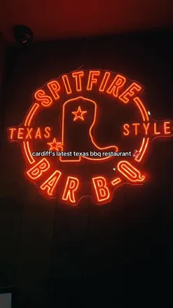 Delicious barbecue meal at Spitfire BBQ in Cardiff, featuring half chicken, pulled pork roll, and jalapeño cheese sausage.