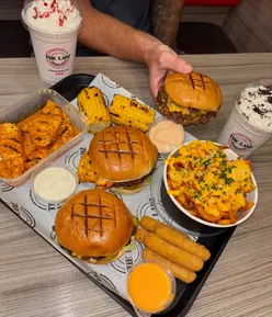 Group of delicious burgers and sides at The Ladz in Cardiff, showcasing their mouthwatering menu items.