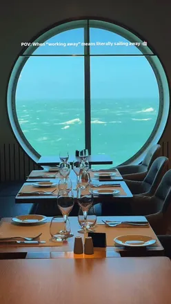 Person enjoying coffee and buffet on Brittany Ferries while working remotely with a view of blue waters.