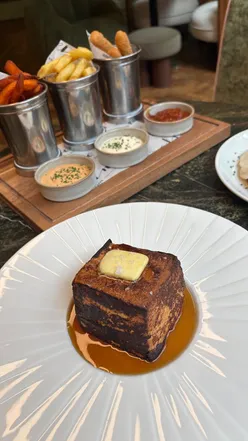 Brunch at The Delphine, a trendy spot in Glasgow, featuring caramelized dulce de leche French toast and cocktails.