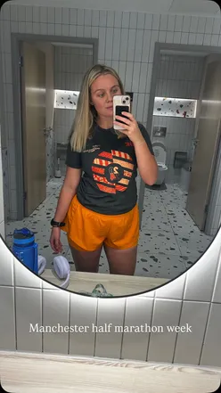 Runner stretching at the gym before the Manchester Half Marathon, focusing on fitness and preparation.