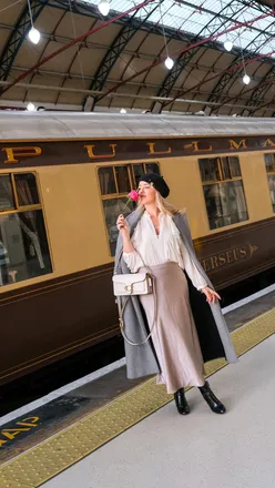 Couple enjoying a luxurious lunch on the vintage Belmond British Pullman train amidst stunning countryside views.