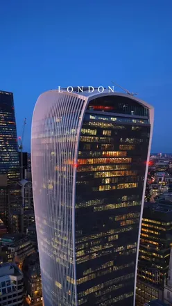 Romantic night view of London with iconic landmarks like St Paul’s Cathedral and The Shard illuminated.