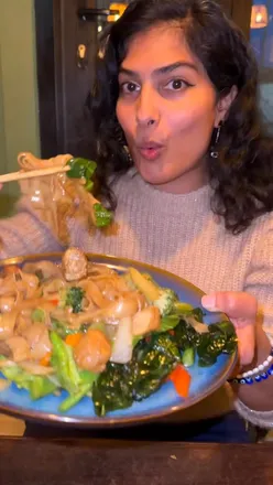 Delicious vegan Drunken Noodles and Thai Tea at Green Curry Thai Café in Wandsworth, showcasing authentic flavors.