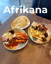 Delicious spread at Afrikana on Wilmslow Road: jerk wings, fried chicken on brioche, flatbread, and refreshing fruit punch.