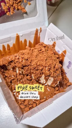 Delicious desserts from Pure Sweet Glasgow, featuring knafeh buns, Biscoff cheesecake, and assorted donuts at a drive-thru.