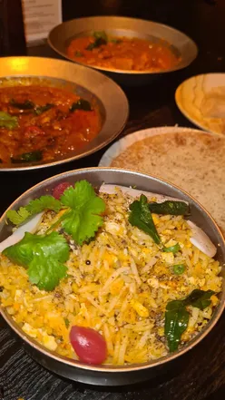 Delicious Kerala dishes including curries, porotta, and cheesecake at Kerala Canteen in Leeds, inviting atmosphere and friendly staff.