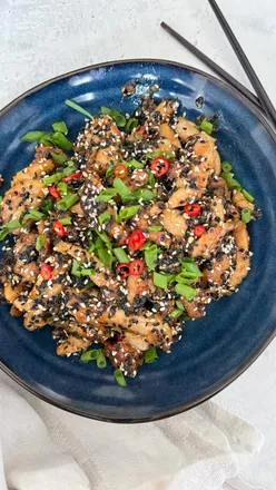 Delicious sticky sesame chicken made with Kikkoman soy sauce, garnished with sesame seeds and chillies, perfect for family dinners.