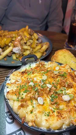 Enjoying a spice bag with curry sauce at a trendy bar in Edinburgh, perfect for pairing with a pint.