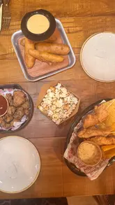 Diners enjoying BBQ dishes at Hickory's Smokehouse in Cardiff, a must-visit for comfort food lovers.