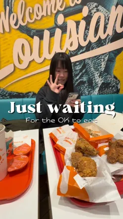 Excited diner waiting to feast on crispy fried chicken at Popeyes in Manchester Arndale, showcasing flavorful wings.