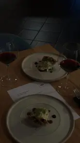 Group enjoying fine dining at a chic restaurant in Leeds, sharing laughs over wine and gourmet dishes.