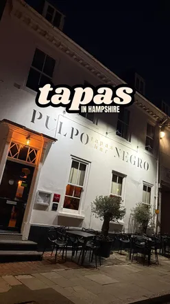 Couple enjoying tapas dishes at Pulpo Negro in Alresford, known for its Michelin bib and exceptional dining experience.