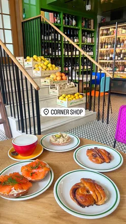Colorful café interior at Corner Shop 180, showcasing delicious bagels and pastries in a vibrant atmosphere.