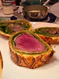 Guests enjoying modern British cuisine at The Grill, relaunch at The Dorchester, featuring Beef Wellington and Baked Alaska.