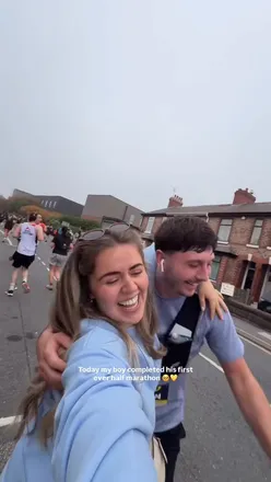 Person celebrating after the Manchester Half Marathon, enjoying a curry delivery while relaxing on the sofa.