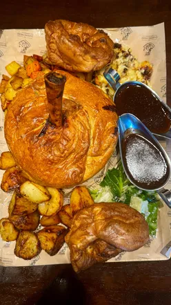 Group enjoying a big roast sharing board with lamb shank pie and snacks at The Queens Head in Harpenden.