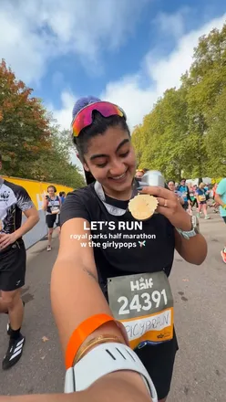 Runner celebrating a successful half marathon with friends, sharing smiles and filming moments during the race.