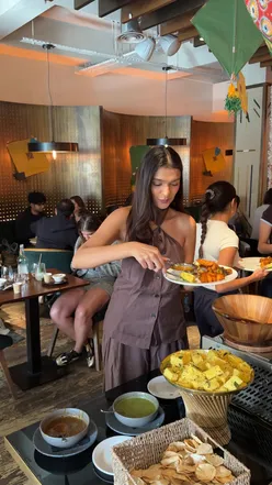 Guests enjoying an Indian street food bottomless brunch at Farzi London, featuring buffet starters and live entertainment.