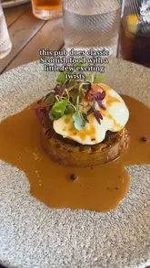 Guests enjoying lunch at The Jigger Inn with views of the Old Course in St Andrews, featuring haggis crumpet and Scottish pub fare.