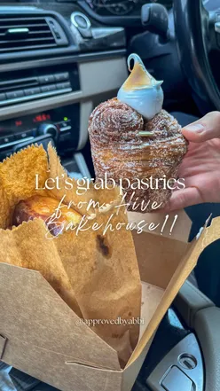 Enjoying a cinnamon bun and pistachio cruffin from Hive Bakehouse during a cozy car picnic at Cup & Crumb Coffee.